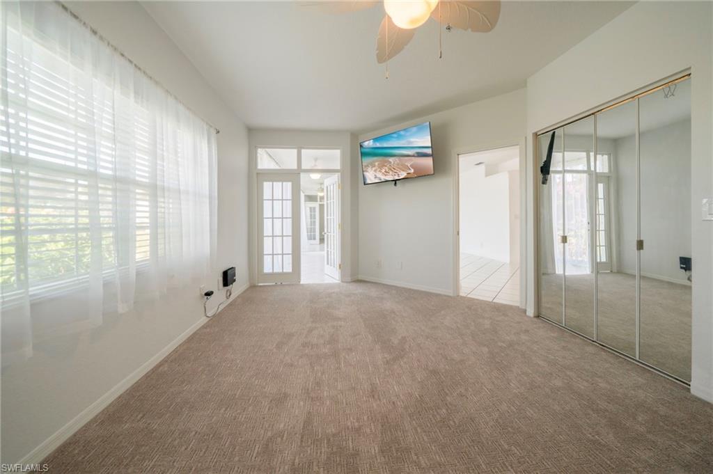 Carpeted empty room featuring a ceiling fan and baseboards
