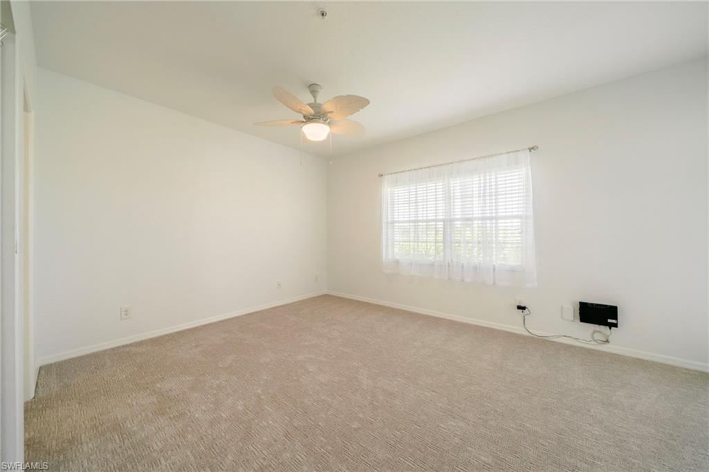 Empty room with light carpet and ceiling fan