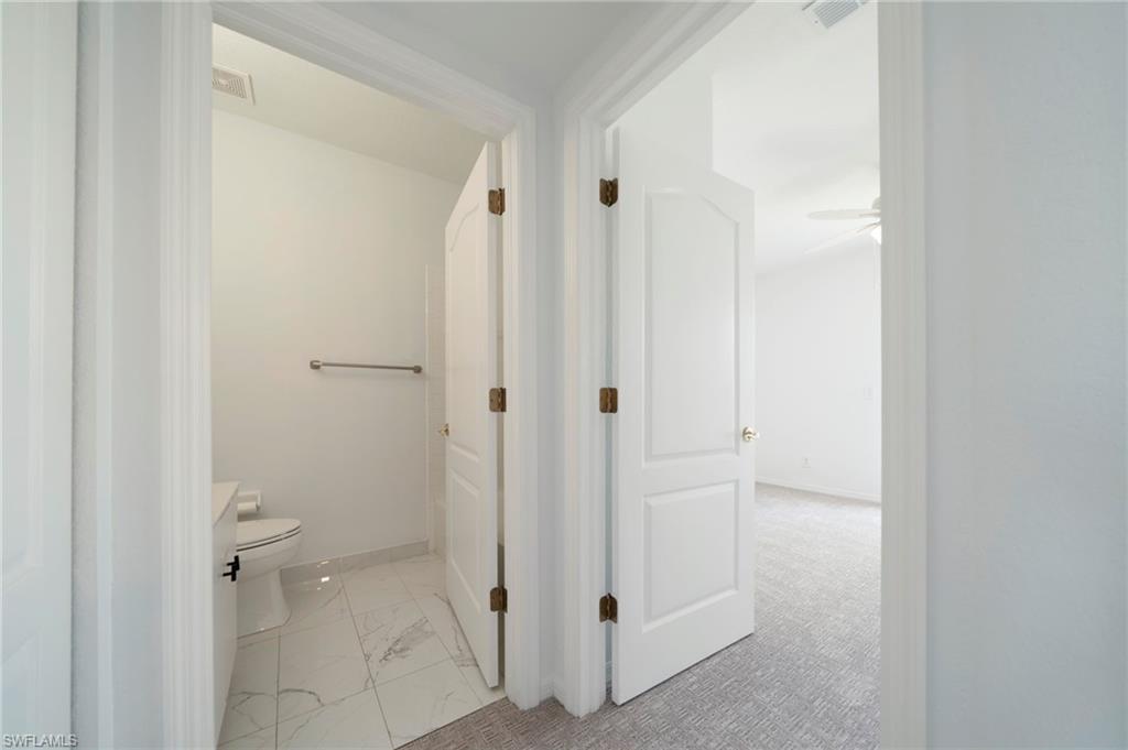 Bathroom featuring toilet and light marble finish floors