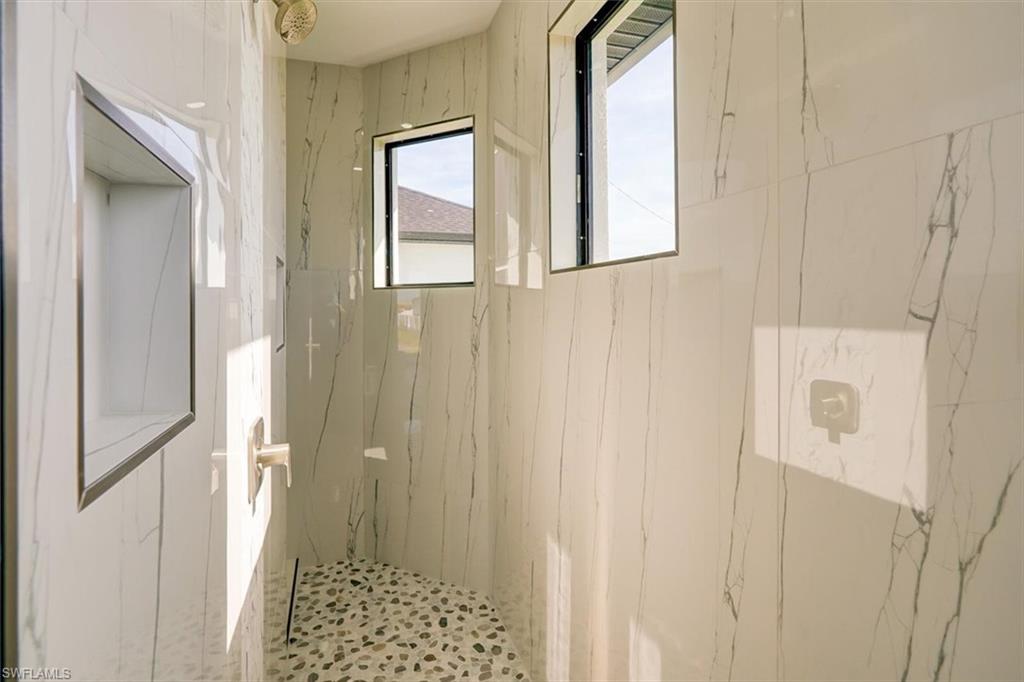 Full bath with a marble finish shower