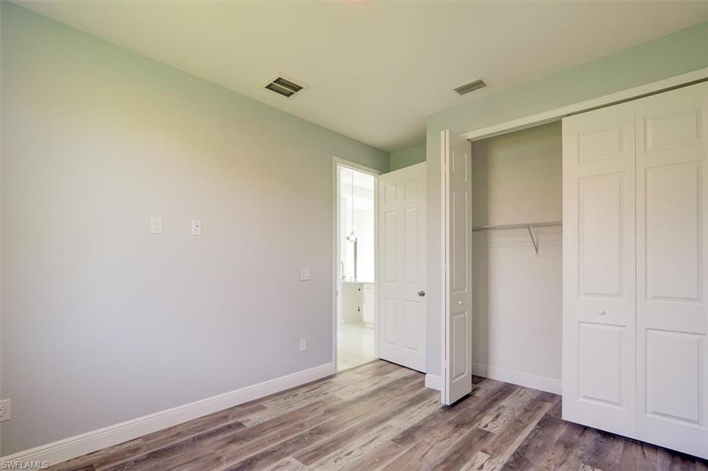 Unfurnished bedroom with wood finished floors and a closet
