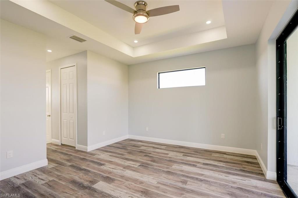 Spare room with recessed lighting, light wood-type flooring, a raised ceiling, and ceiling fan