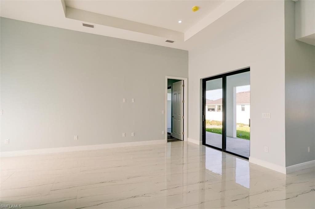Spare room featuring a raised ceiling, recessed lighting, and a towering ceiling