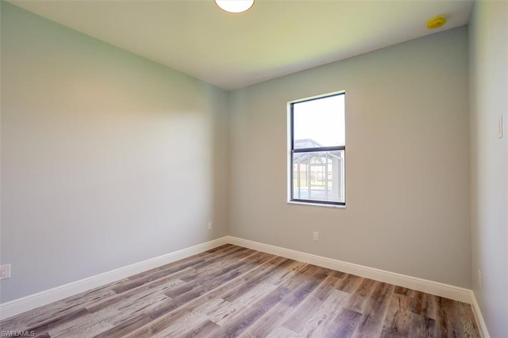 Unfurnished room with baseboards and wood finished floors