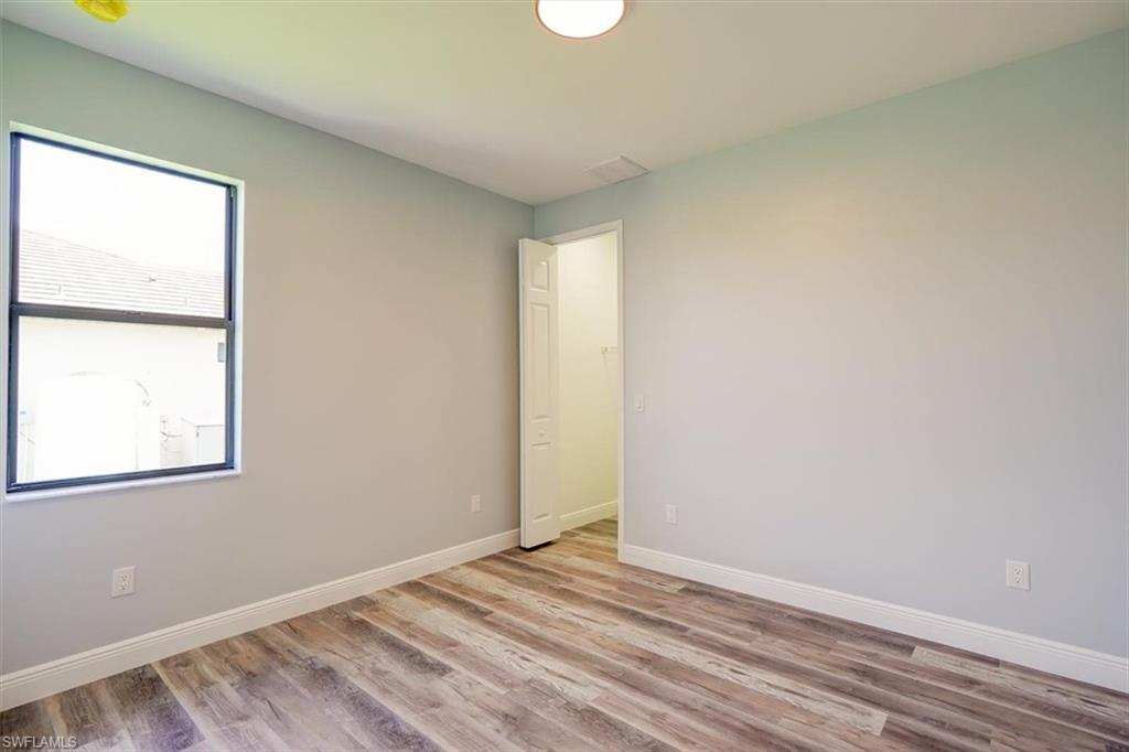 Unfurnished room featuring light wood finished floors and baseboards