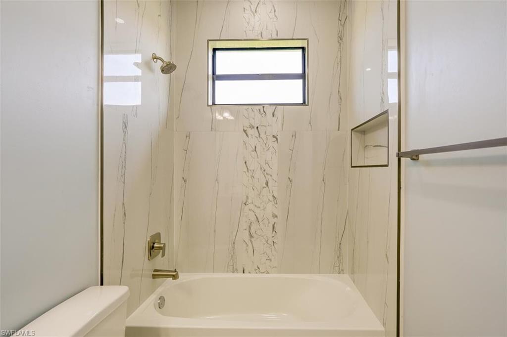 Bathroom with bathing tub / shower combination and toilet