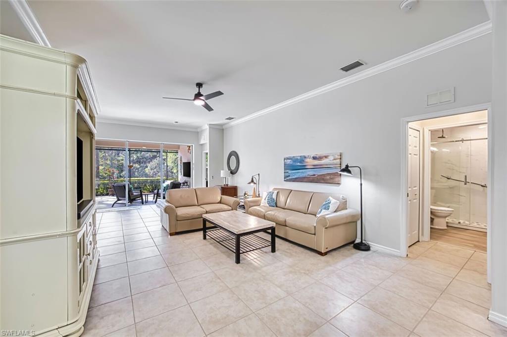 Living room featuring a ceiling fan, crown molding, and light tile patterned flooring