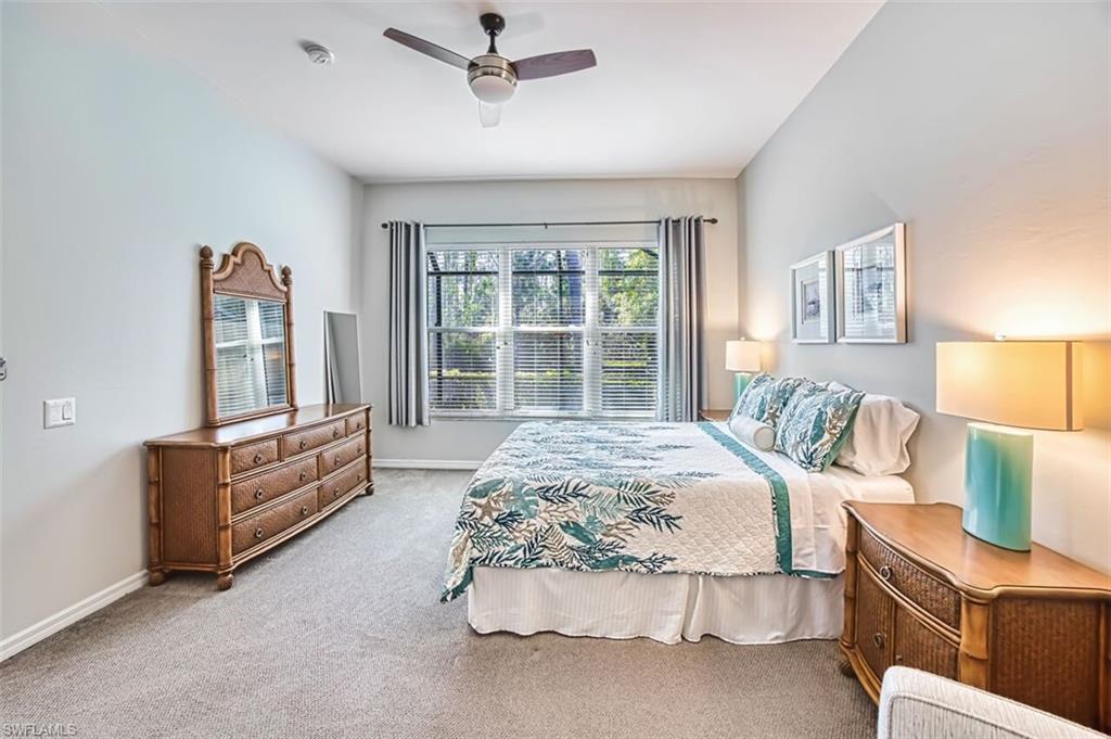 Carpeted bedroom featuring a ceiling fan and baseboards
