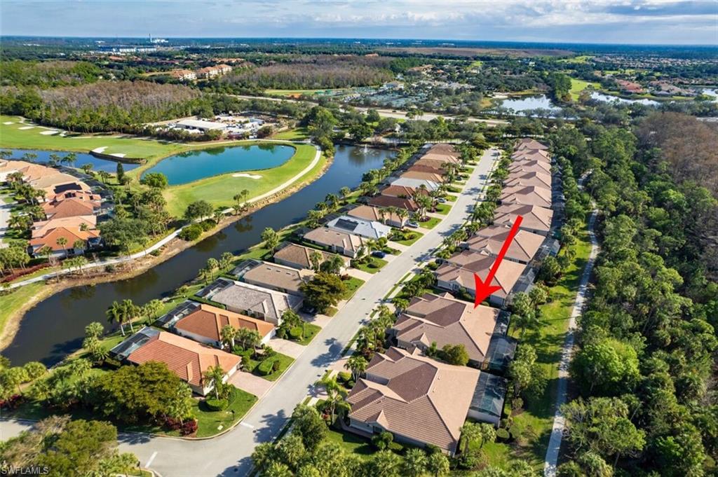 Aerial view of property's location with a nearby body of water, nearby suburban area, and a golf course