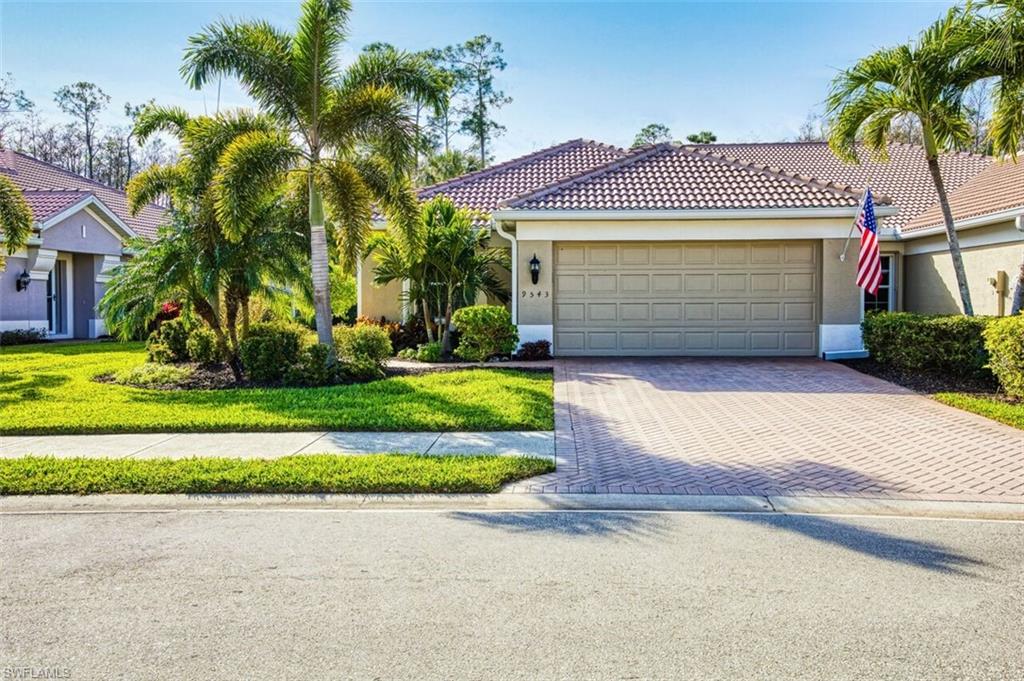 View of front facade featuring stucco siding, decorative driveway, a front yard, a garage, and a tile roof
