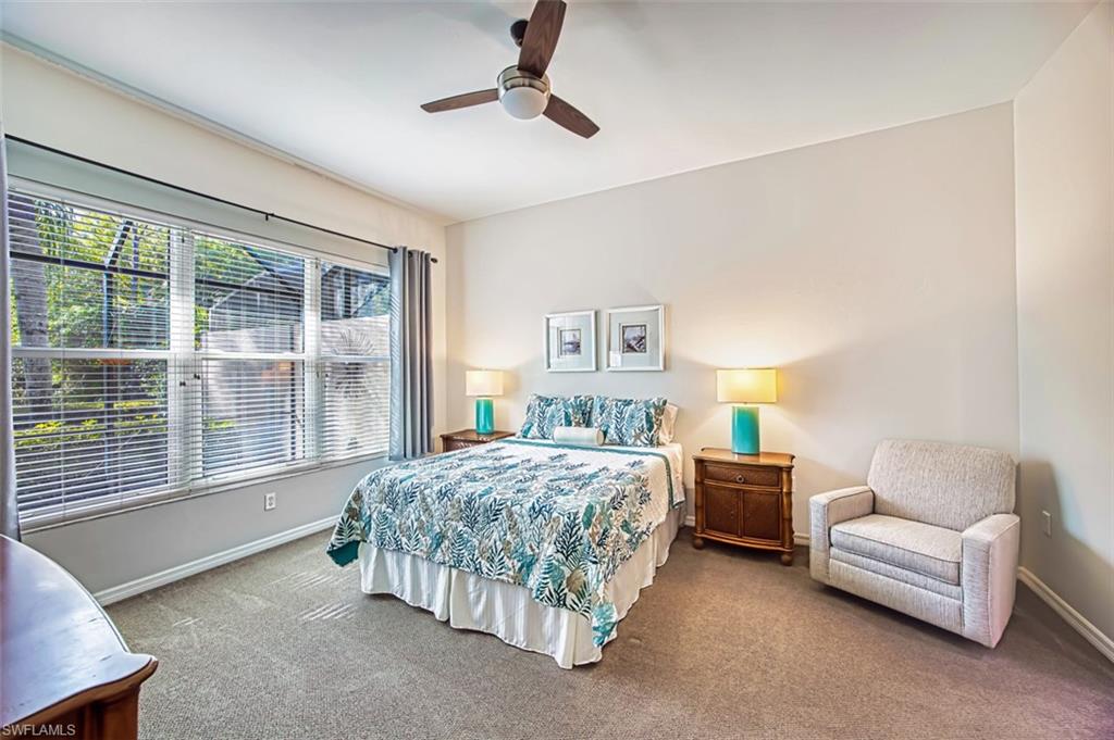 Carpeted bedroom featuring a ceiling fan and baseboards