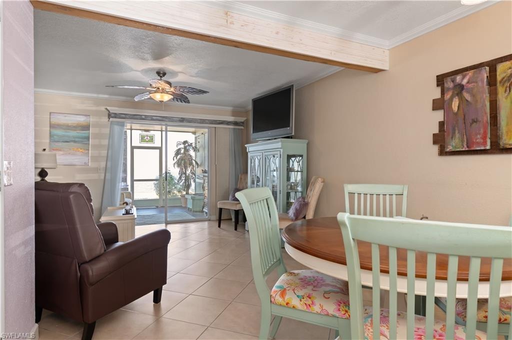 Dining space featuring ornamental molding, tile patterned flooring, and a ceiling fan