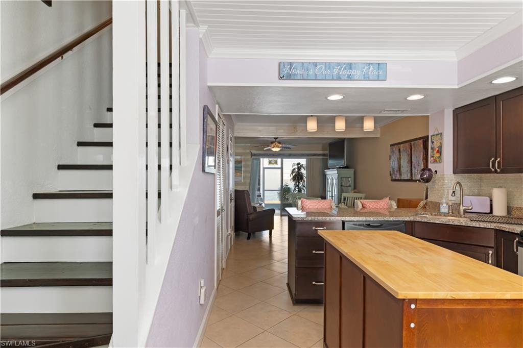 Kitchen with butcher block countertops, dark wood finish cabinets, ceiling fan, a peninsula, and recessed lighting