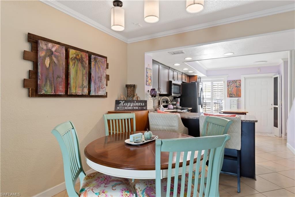 Dining room featuring crown molding, recessed lighting, and light tile patterned floors