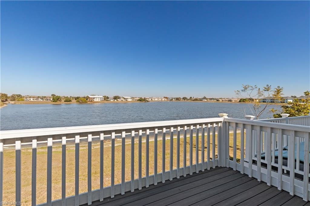 Wooden deck with a water view, a residential view, and a lawn