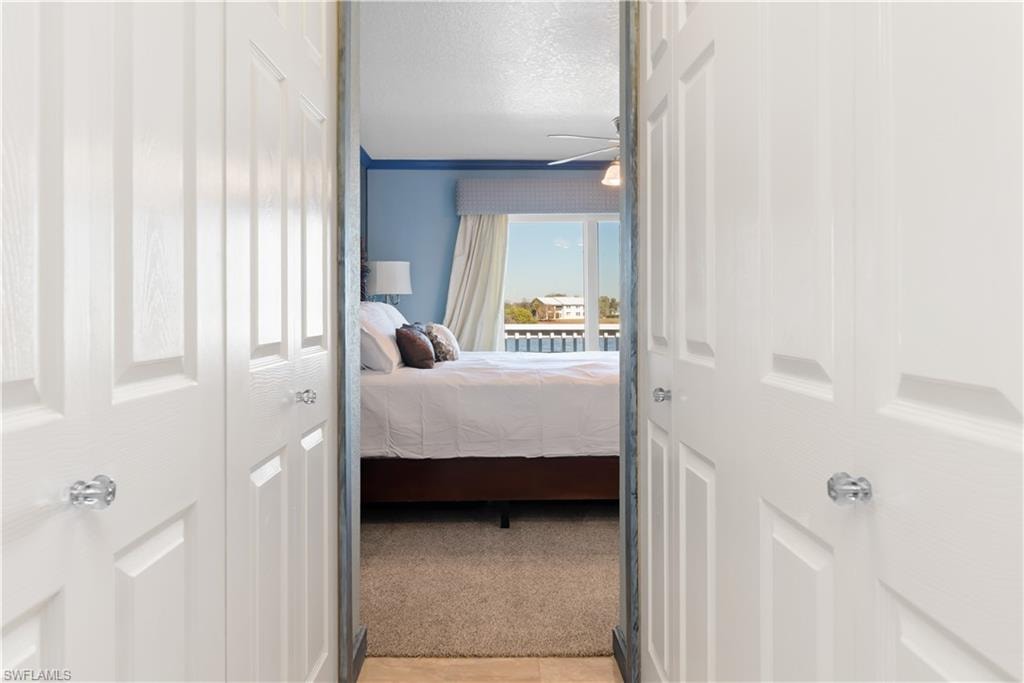 Bedroom featuring a closet, a textured ceiling, and light carpet