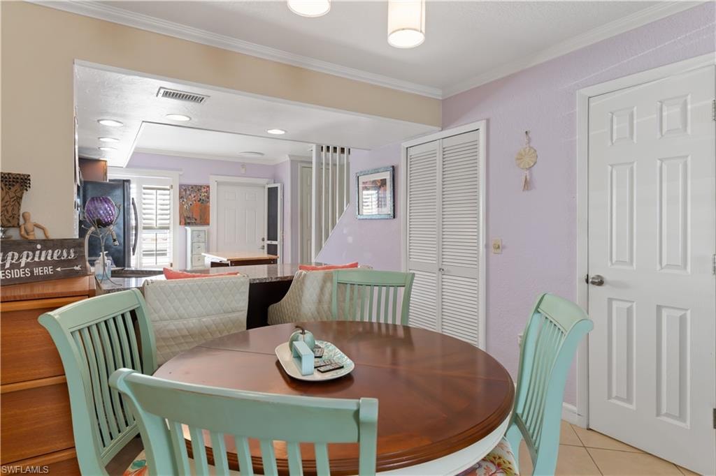 Dining room featuring ornamental molding and light tile patterned floors