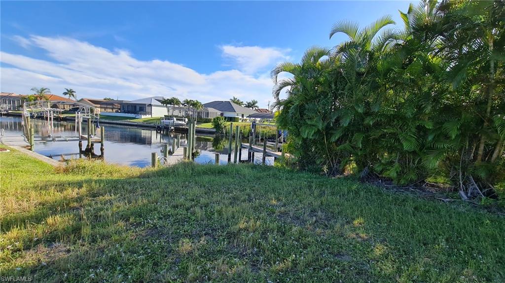 Dock featuring boat lift, a water view, and a residential view