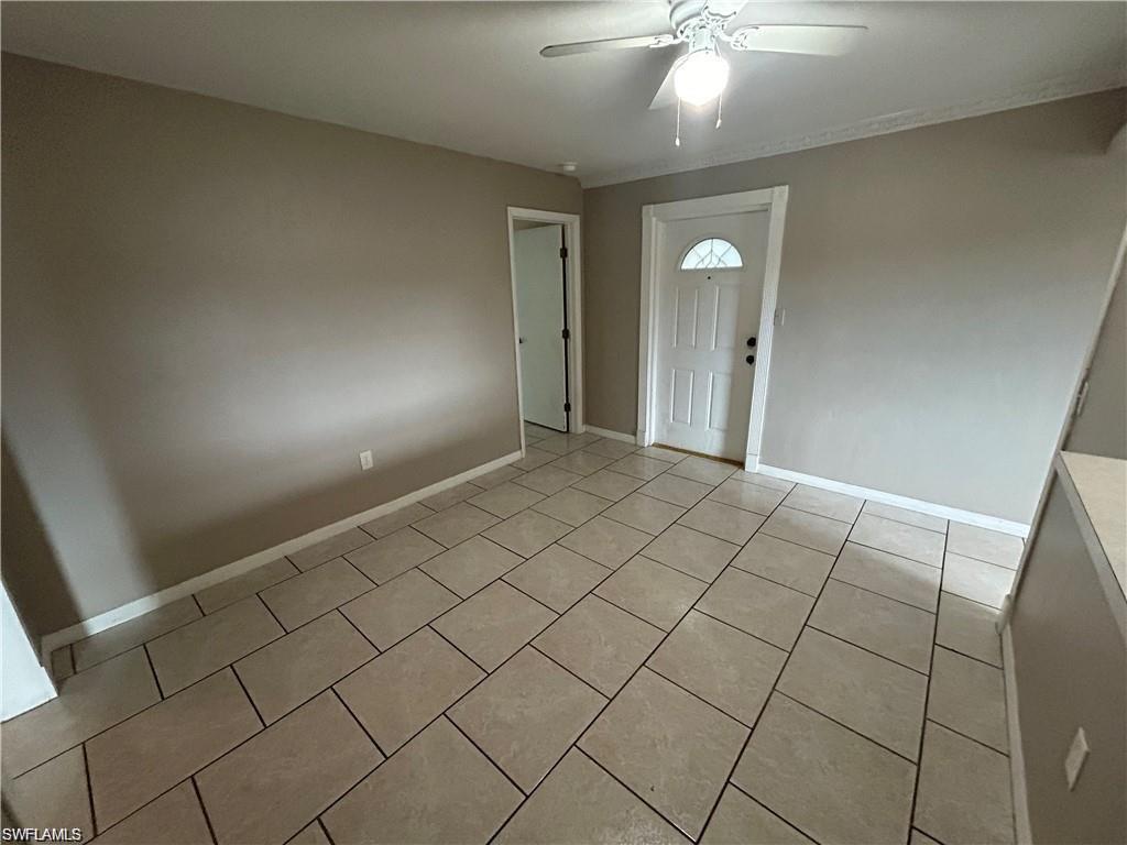Entryway featuring light tile patterned floors and a ceiling fan