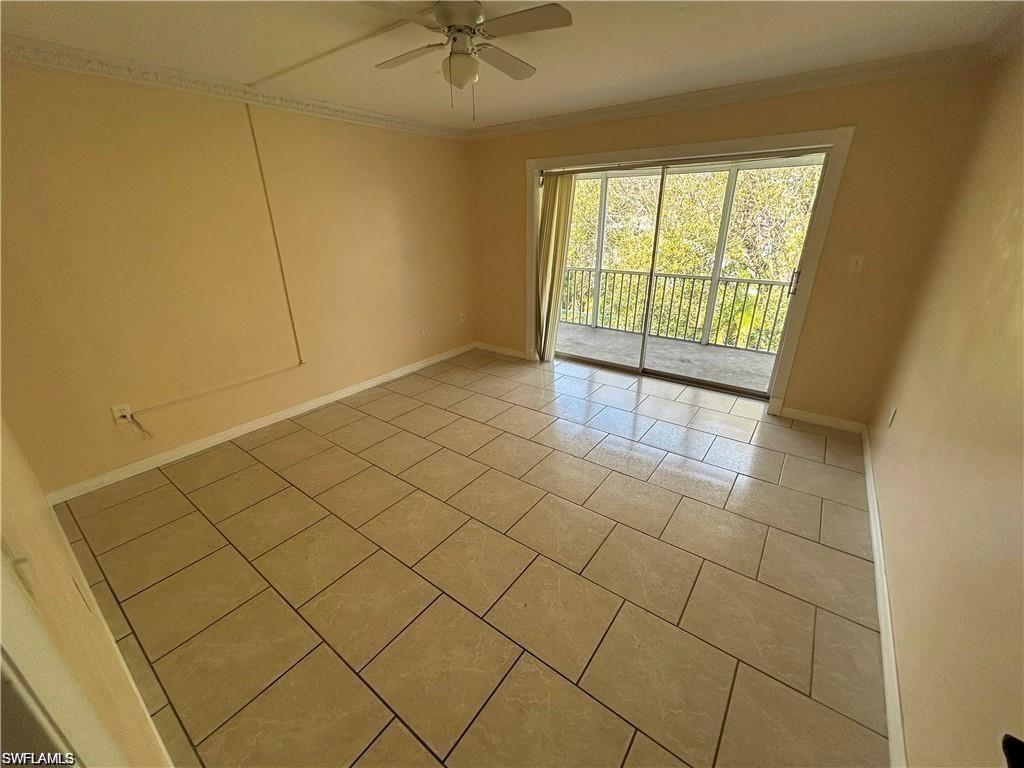 Spare room featuring ornamental molding, tile patterned flooring, and a ceiling fan