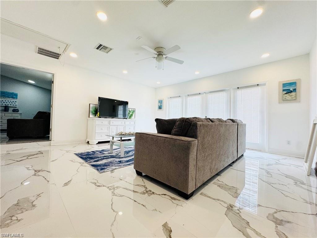 Living room with light marble finish floors, a ceiling fan, and recessed lighting