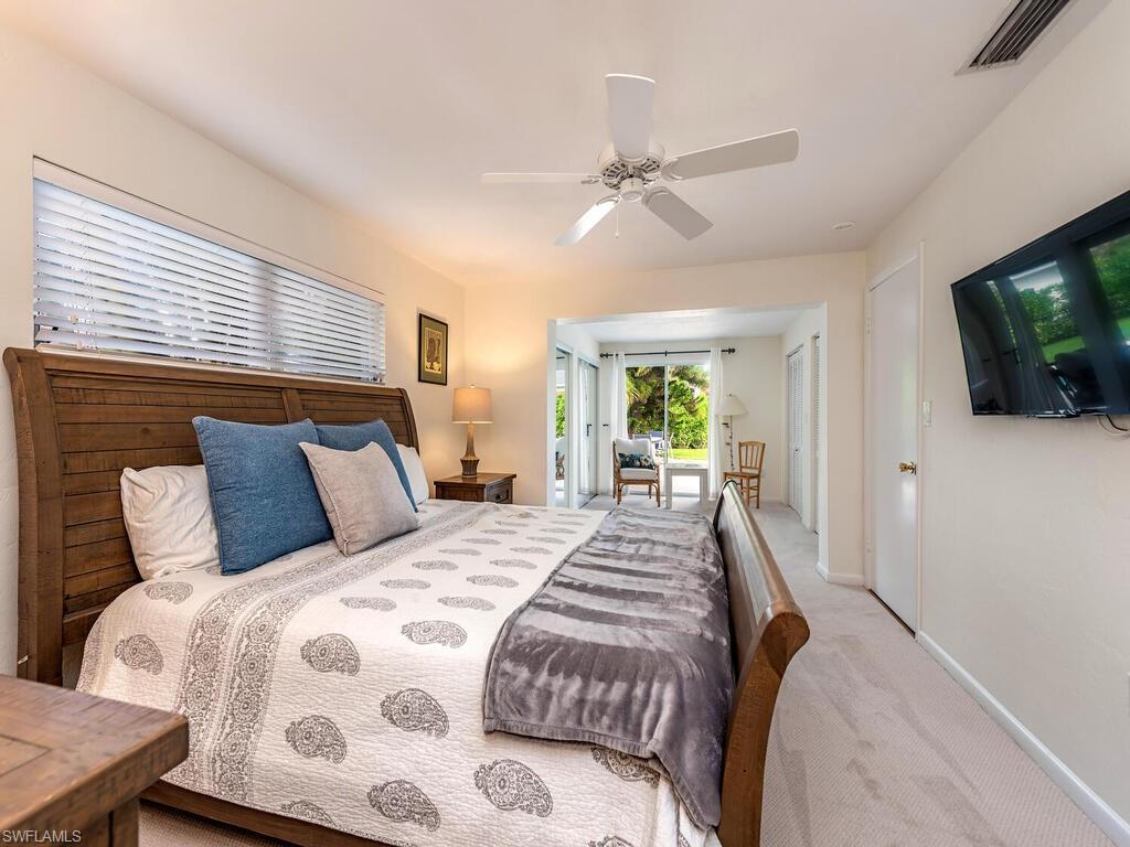 Carpeted bedroom with baseboards, visible vents, ceiling fan, and access to exterior