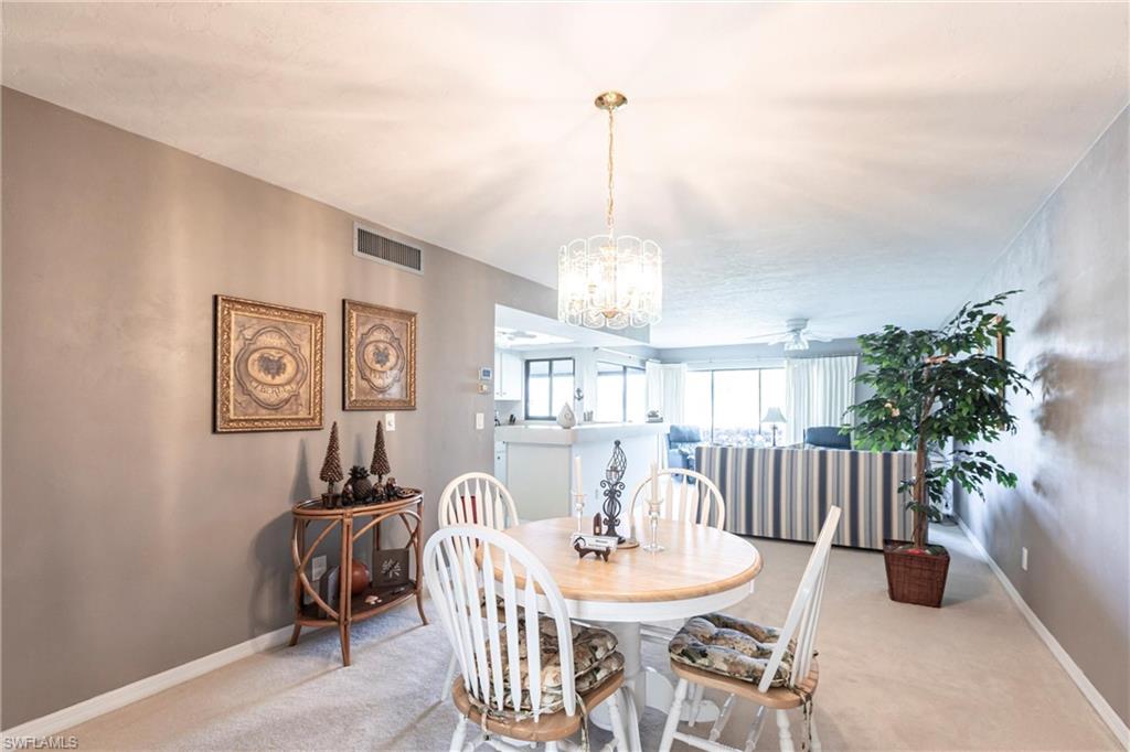 Dining area featuring carpet flooring, ceiling fan, and a chandelier