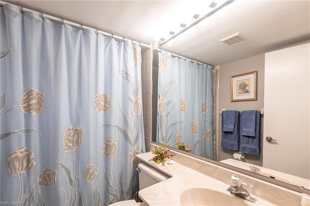 Full bath with curtained shower and vanity