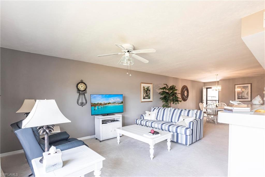 Living area featuring light carpet and a ceiling fan