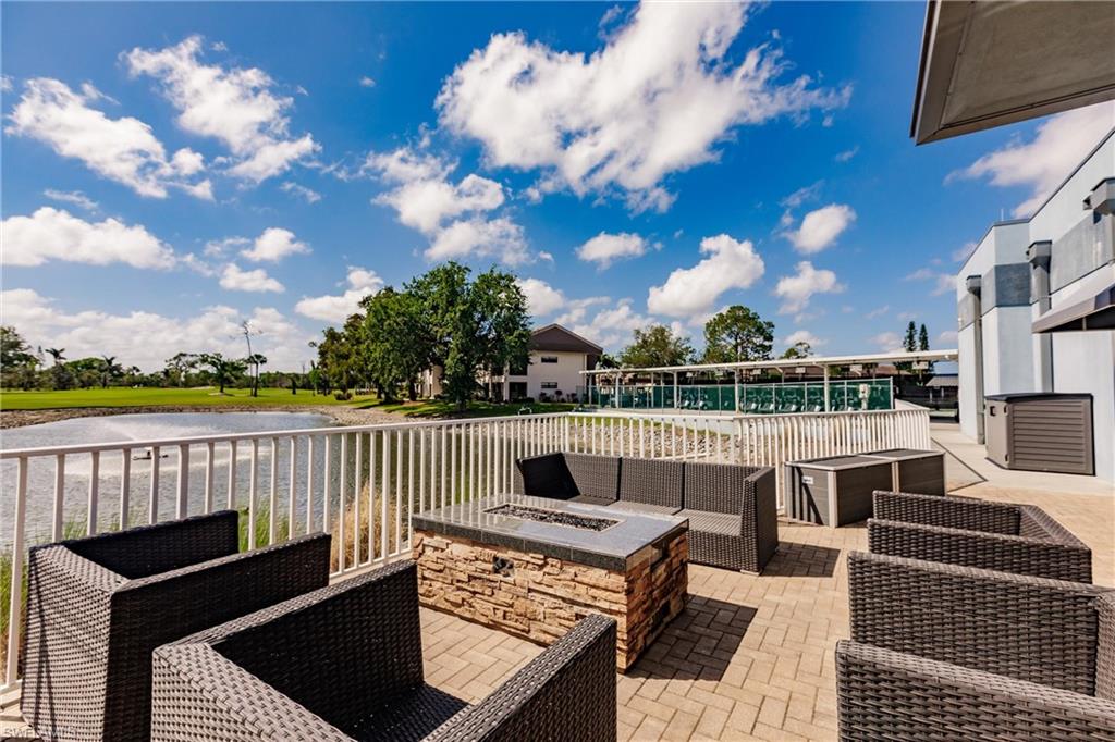 View of patio featuring an outdoor living space with a fire pit and a water view