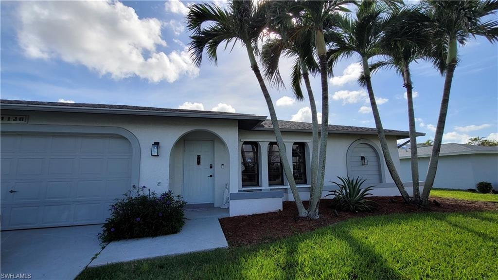 Ranch-style home with a front lawn and an attached garage