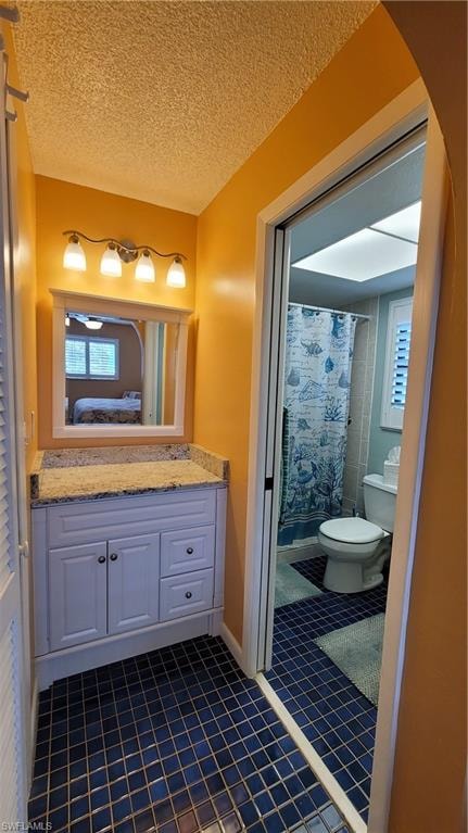 Ensuite bathroom with curtained shower, toilet, ensuite bathroom, vanity, and a textured ceiling