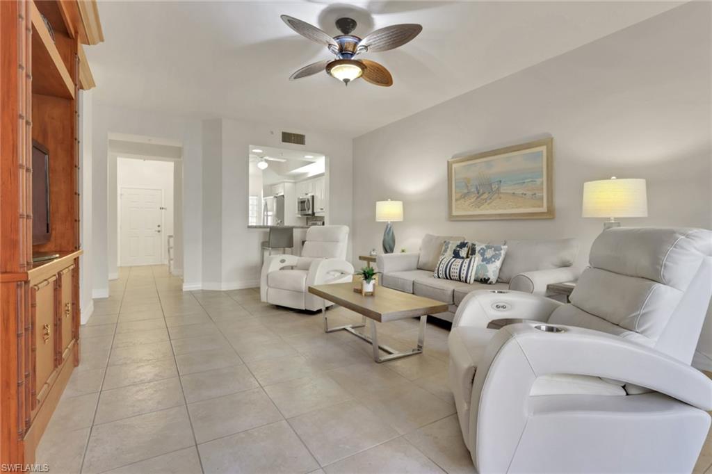 Living room with light tile patterned floors and a ceiling fan