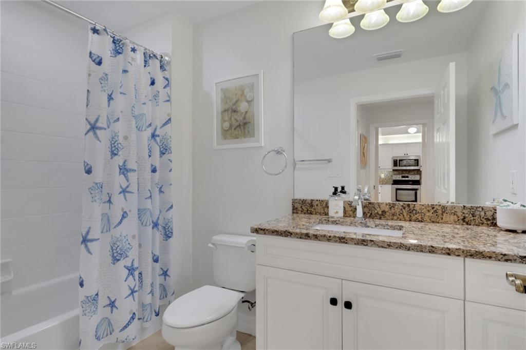 Bathroom featuring vanity and shower / tub combo with curtain
