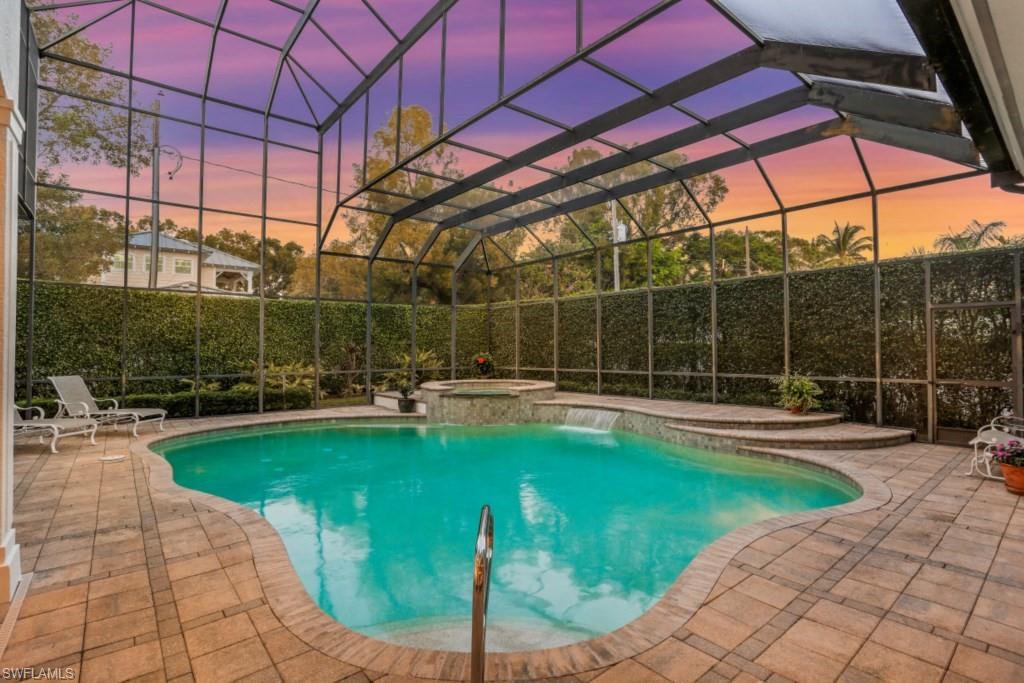 View of pool featuring an in ground hot tub, a fenced in pool, a lanai, and a patio area