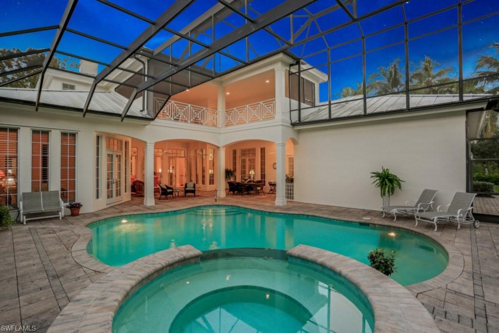 View of pool with glass enclosure, a pool with connected hot tub, french doors, and a patio area