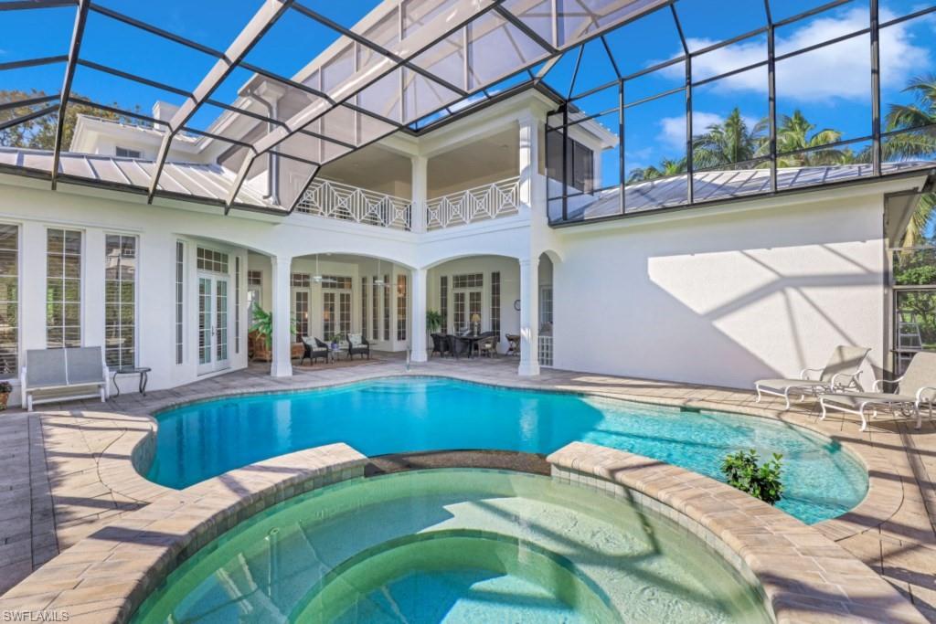 View of swimming pool with glass enclosure, a pool with connected hot tub, french doors, and a patio area