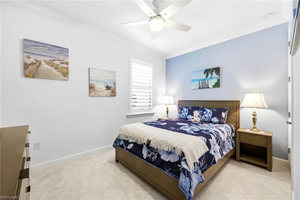 Tiled bedroom with crown molding and ceiling fan