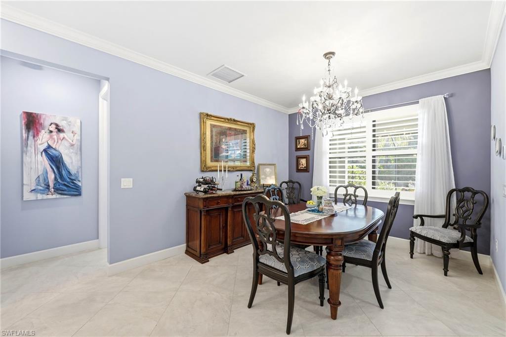 Dining space with ornamental molding and a chandelier