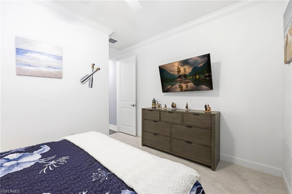 Bedroom with ornamental molding and a ceiling fan