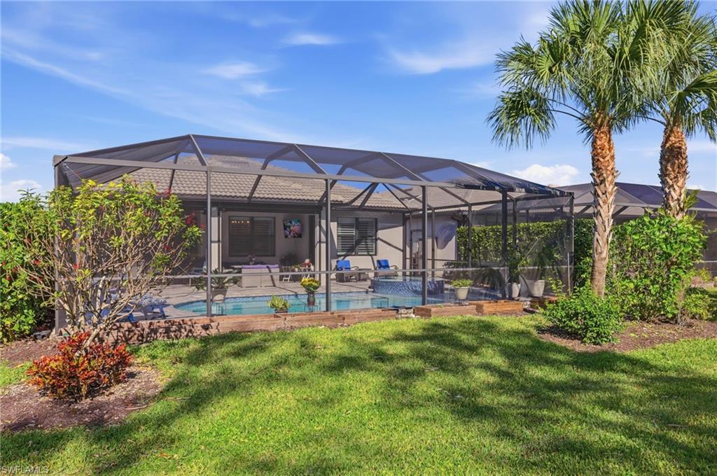 Swimming pool featuring a lanai, a sunroom, and a yard