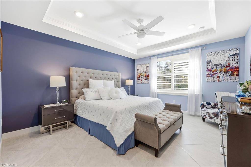 Bedroom featuring ornamental molding, ceiling fan, a raised ceiling, and light tile patterned flooring