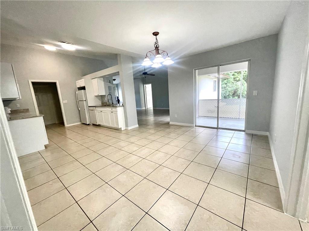 Unfurnished dining area with light tile patterned floors and suspended lighting