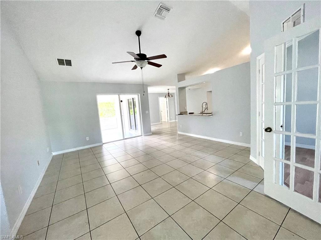 Spare room featuring light tile patterned floors, ceiling fan, and a textured ceiling