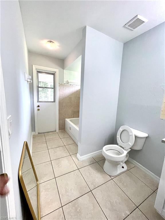 Bathroom with light tile patterned floors and  shower combination