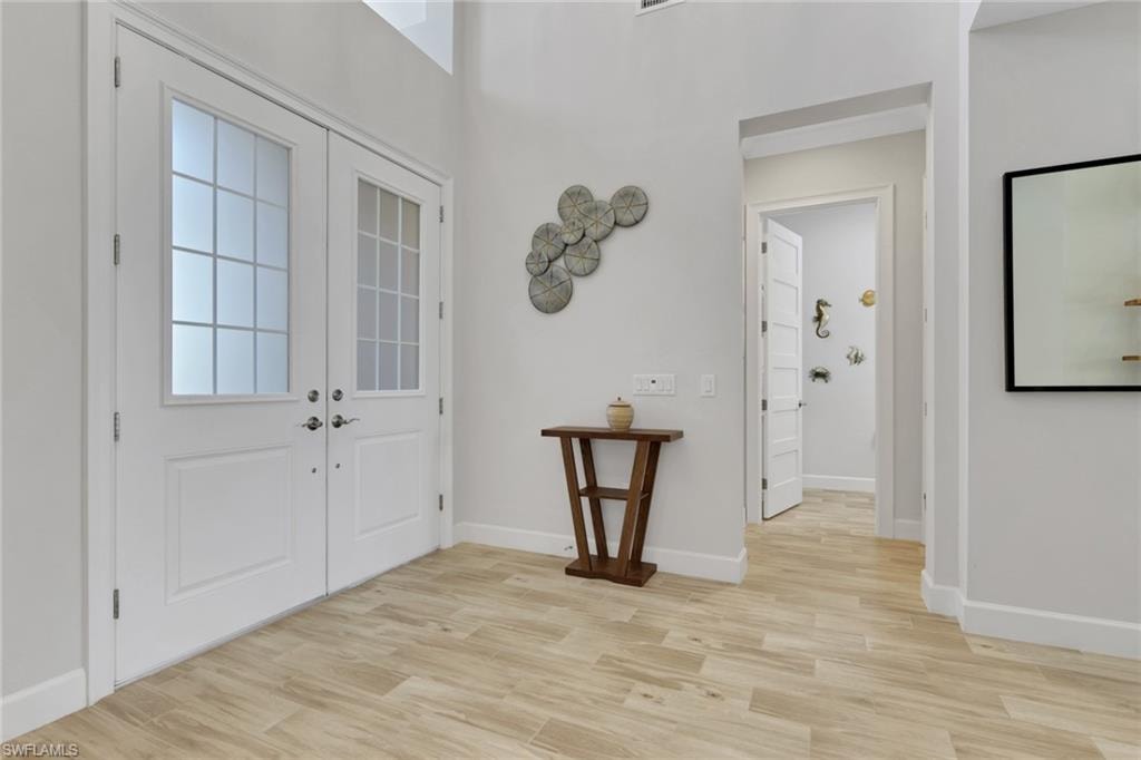 Foyer featuring light wood-type flooring and french doors