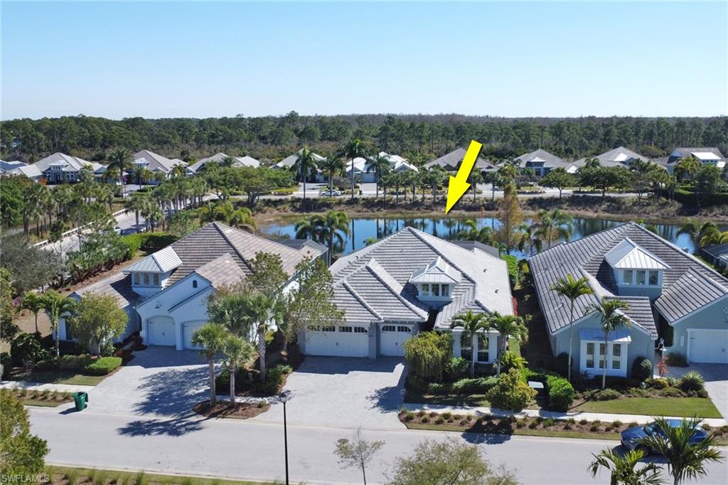 Aerial perspective of suburban area featuring a nearby body of water