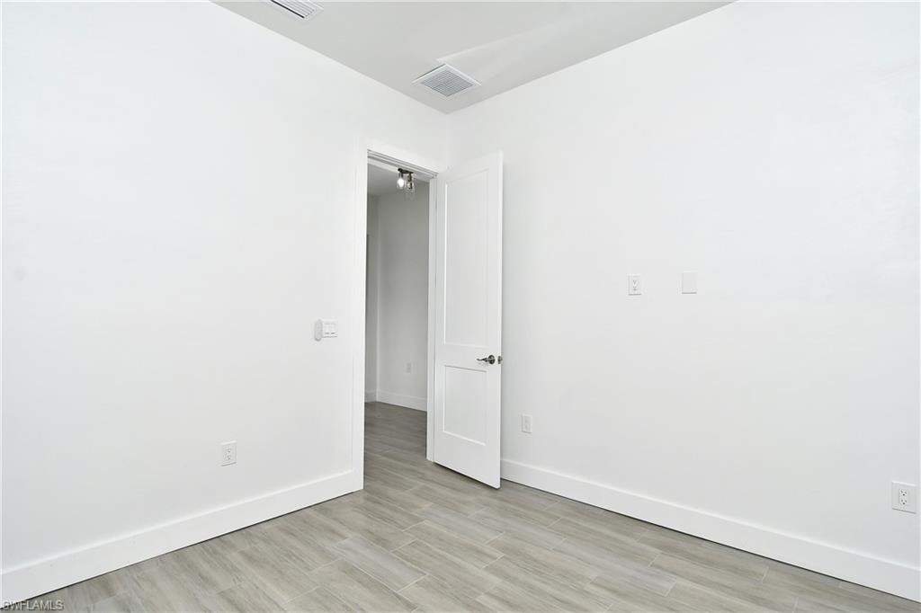 Spare room featuring baseboards and light wood finished floors