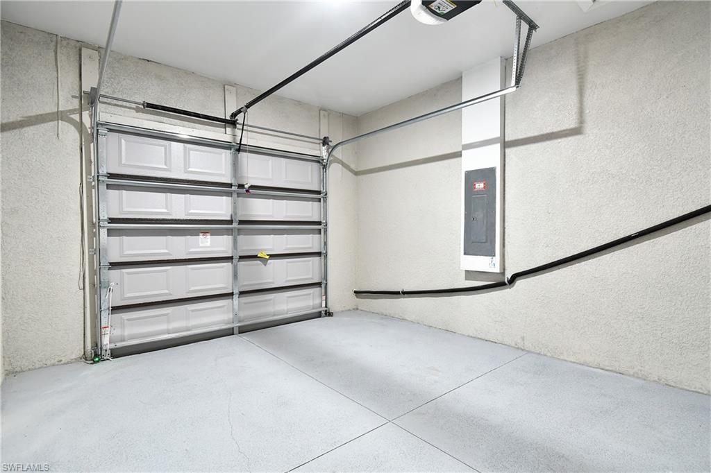 Garage featuring electric panel and a garage door opener
