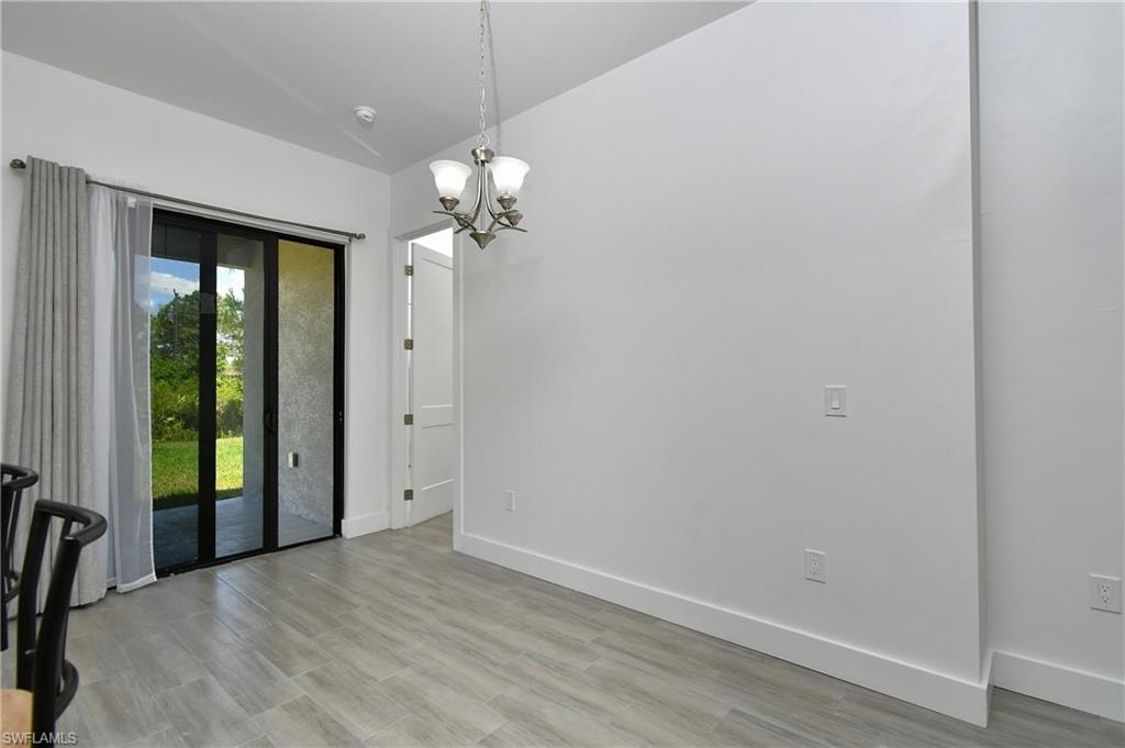 Unfurnished dining area featuring suspended lighting and light wood-style floors